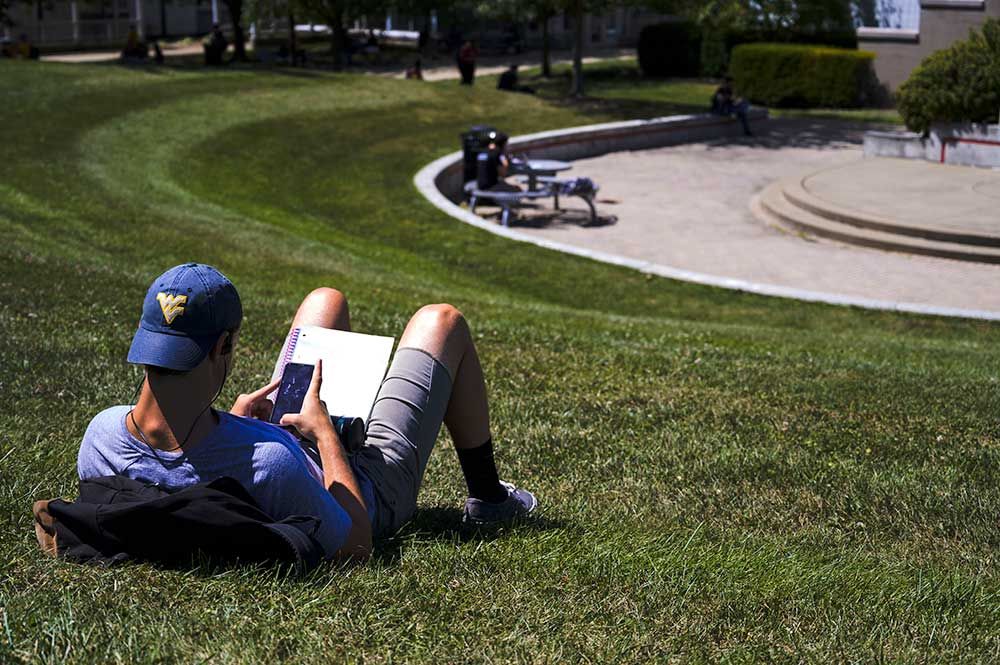 student reading on a lawn