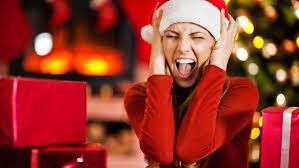 Screaming woman wearing a Santa hat in front of a Christmas tree